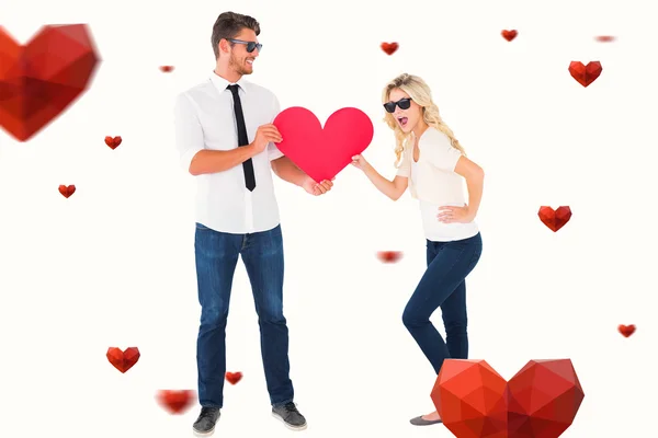 Cool mladý pár drží červené srdce — Stock fotografie