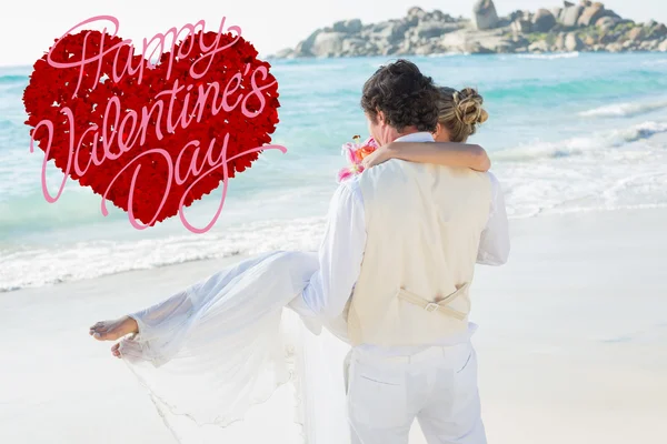 Handsome groom carrying his beautiful wife — Stock Photo, Image