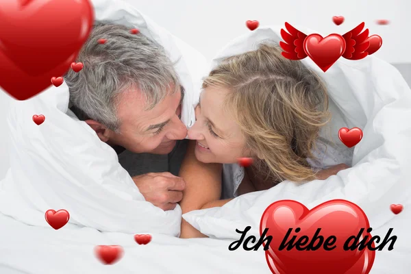Kärleksfull mitten äldre par under täcket — Stockfoto