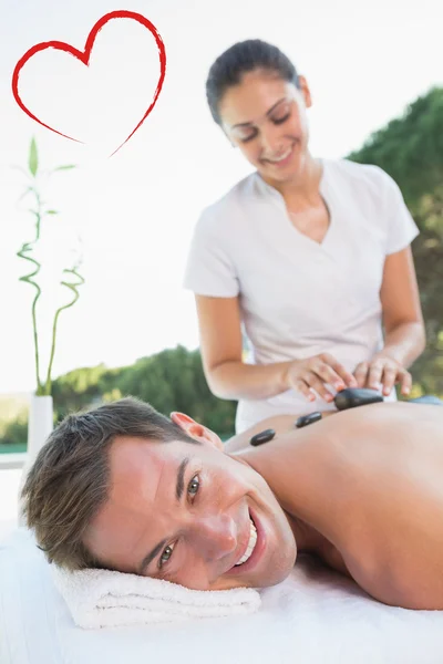 Man att få en hot stone massage pool — Stockfoto