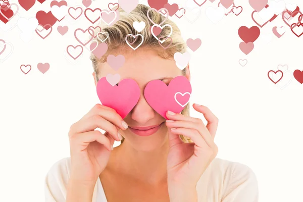 Atractiva rubia sosteniendo corazones sobre los ojos — Foto de Stock