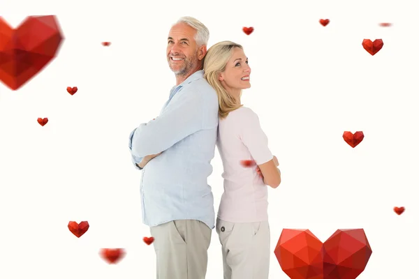 Smiling couple standing leaning backs together — Stock Photo, Image