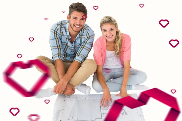 Couple sitting looking at blueprint — Stock Photo, Image