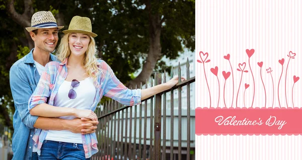 Hip young couple smiling at camera by railing — Stock Photo, Image