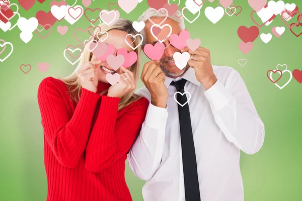 Fåniga par hålla hjärtan över deras ögon — Stockfoto