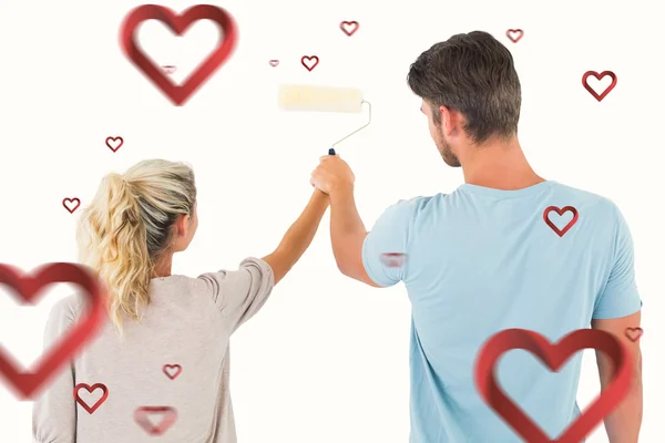 Pintura jovem casal com rolo — Fotografia de Stock