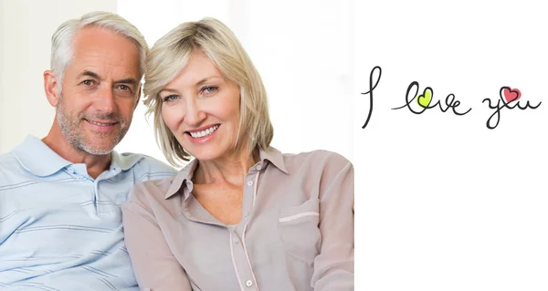 Smiling mature couple sitting on sofa — Stock Photo, Image