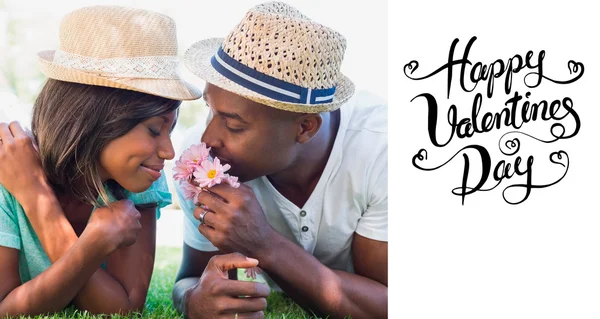 Happy couple lying in garden together smelling — Stock Photo, Image