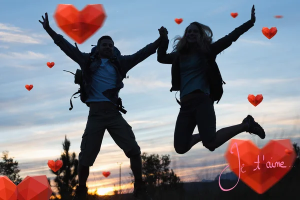 Silhouette couple jumping against the sky — Stock Photo, Image