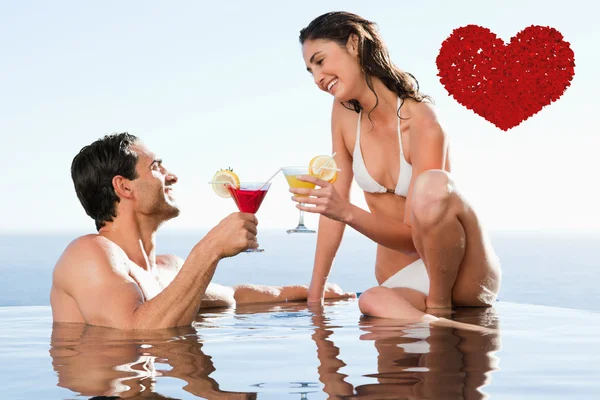 Coppia che beve cocktail in piscina — Foto Stock