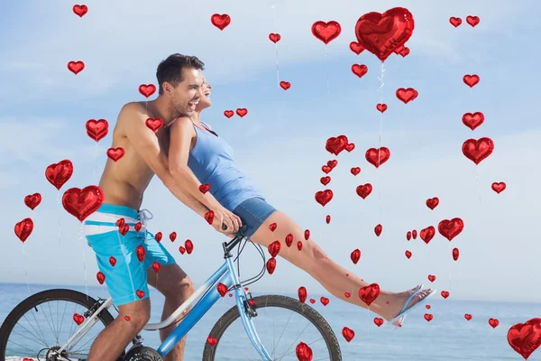 Man giving girlfriend a lift on his crossbar — Stock Photo, Image