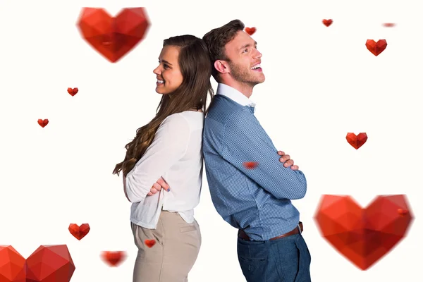 Happy young couple standing back to back — Stock Photo, Image