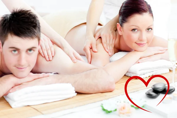 Composite image of loving young couple enjoying a back massage — Stock Photo, Image