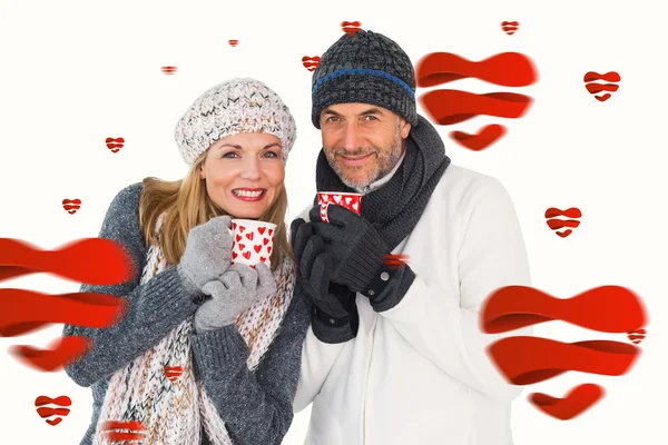 Casal feliz no inverno moda segurando canecas — Fotografia de Stock