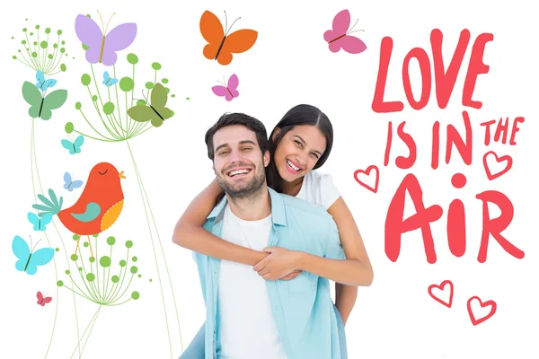 Casual man giving pretty girlfriend piggy back — Stock Photo, Image