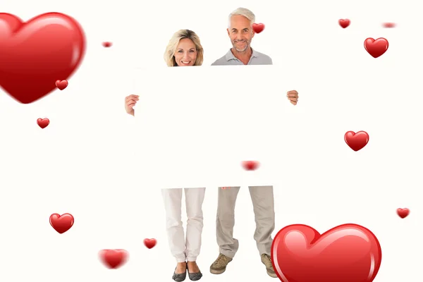 Happy couple holding large poster — Stock Photo, Image