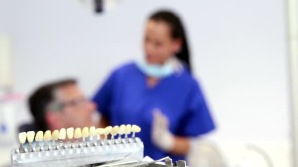 Стоматолог осматривает зубы пациента в кресле стоматолога — стоковое видео