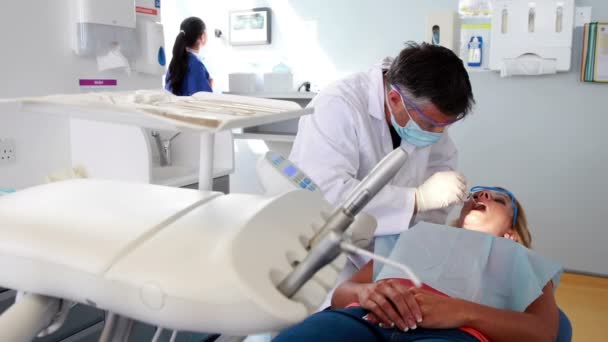 Dentista che esamina un paziente denti — Video Stock