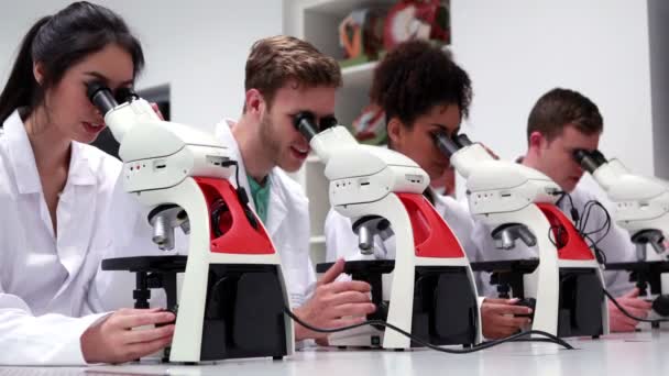 Medische studenten werken met microscopen — Stockvideo