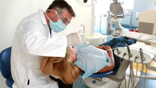 Dentista examinando uma mulher dentes — Vídeo de Stock