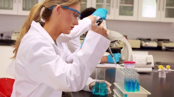 Test tüpü içinde kimyasal koymak için pipet kullanarak bilim adamı — Stok video