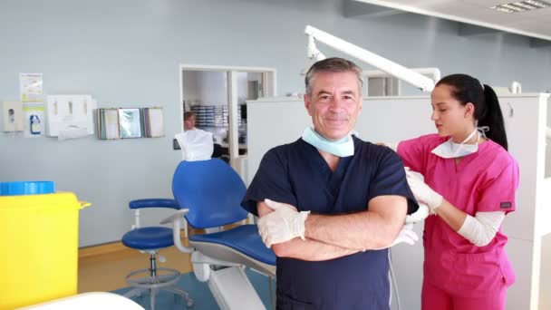 Tandläkare med armar korsade framför hans assistent — Stockvideo