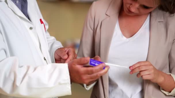 Apotheker zwangerschapstest uit te leggen aan jonge vrouw — Stockvideo