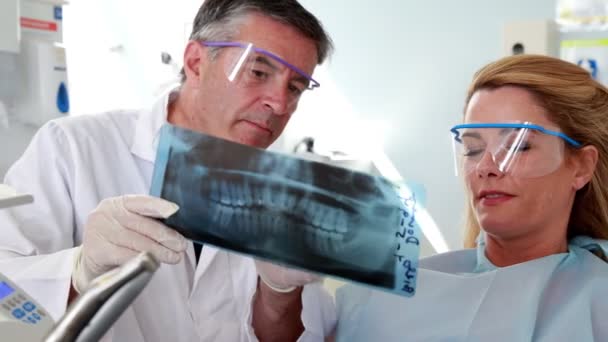 Dentista e paciente olhando raio-x juntos — Vídeo de Stock