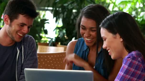 Amigos sonrientes usando el portátil juntos — Vídeos de Stock