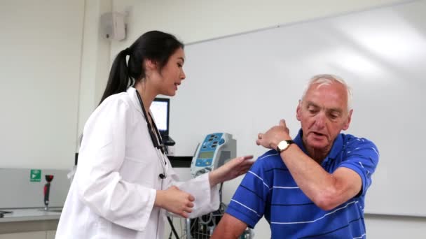 Doctor talking to patient with shoulder pain — Stock Video