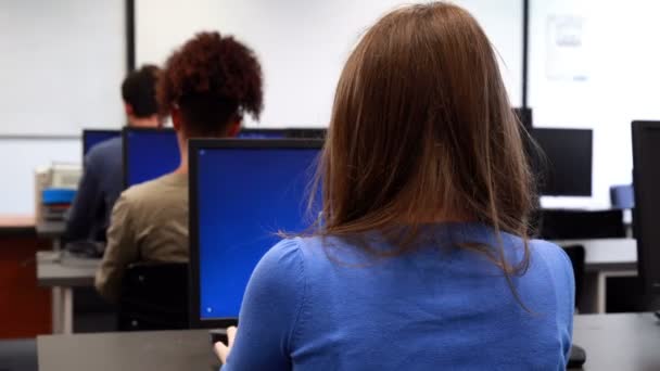 Estudiantes trabajando en sala de ordenadores — Vídeos de Stock