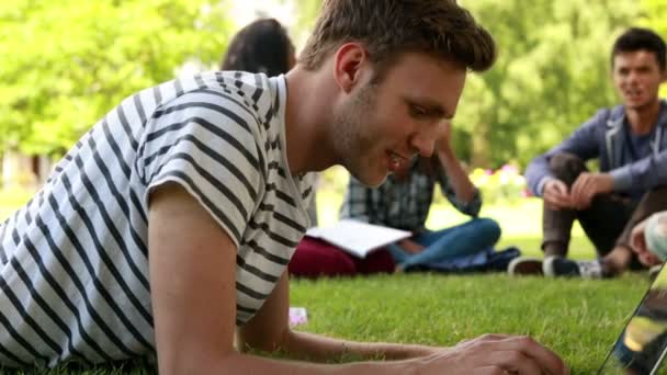 Estudiante usando laptop y compañeros de clase hablando — Vídeos de Stock