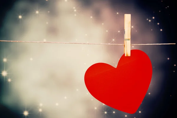 Composite image of heart hanging on line — Stock Photo, Image