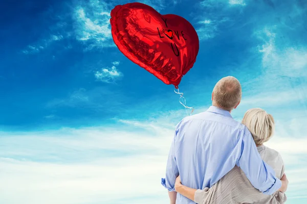 Composite image of mature couple hugging and looking — Stock Photo, Image