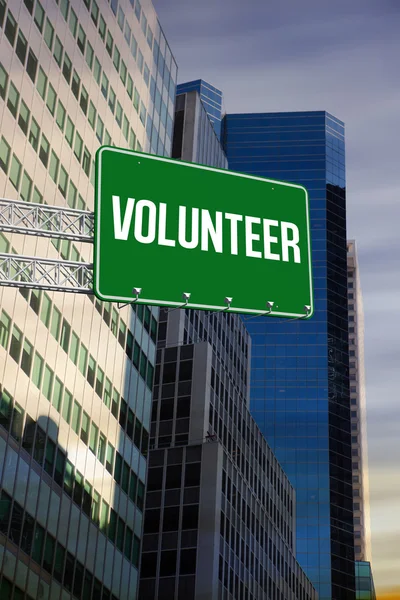 Volunteer against low angle view of skyscrapers — Stock Photo, Image