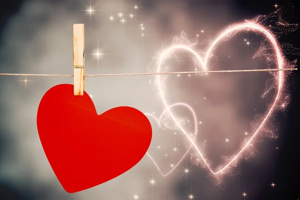 Composite image of heart hanging on line — Stock Photo, Image