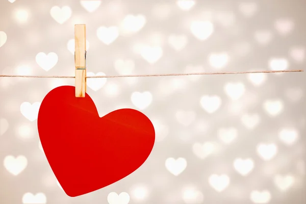 Composite image of heart hanging on line — Stock Photo, Image