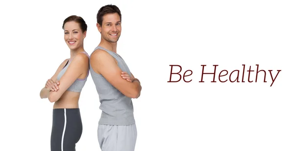 Portrait of a happy fit young couple with hands crossed — Stock Photo, Image