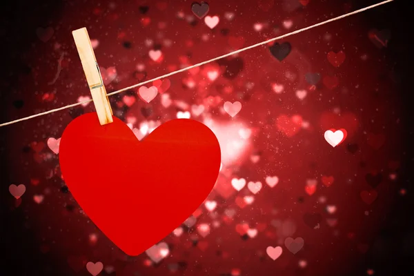 Composite image of heart hanging on line — Stock Photo, Image