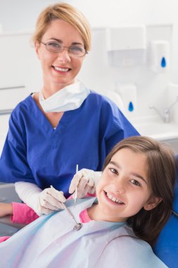 Dentist with a happy young patient clipart