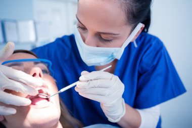 Dentist examining a patients teeth clipart