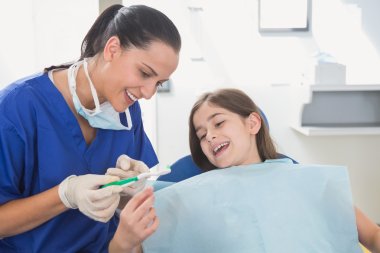 Dentist explaining to young patient clipart