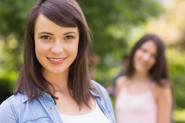 Estudiante bonita sonriendo a la cámara afuera en el campus — Foto de Stock