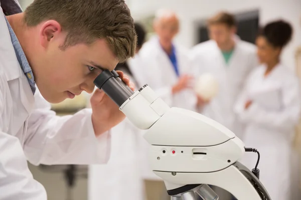 Jovem estudante de medicina trabalhando com microscópio — Fotografia de Stock