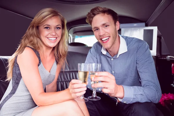 Gelukkige paar drinken champagne in limousine — Stockfoto