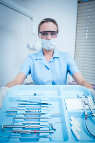 Dentiste en masque chirurgical tenant plateau d'outils — Photo