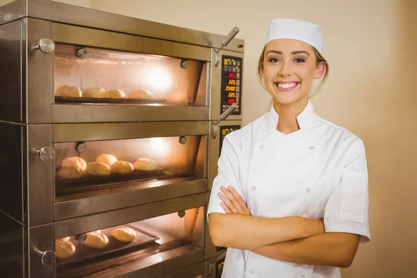 Baker sonriendo a la cámara al lado del horno — Foto de Stock