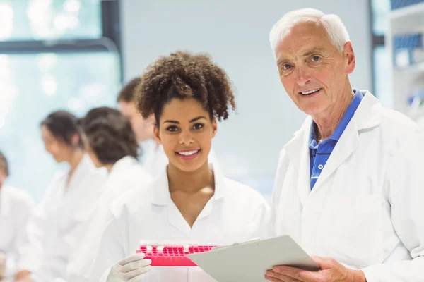 Profesor y estudiante sonriendo a la cámara en el laboratorio — Foto de Stock