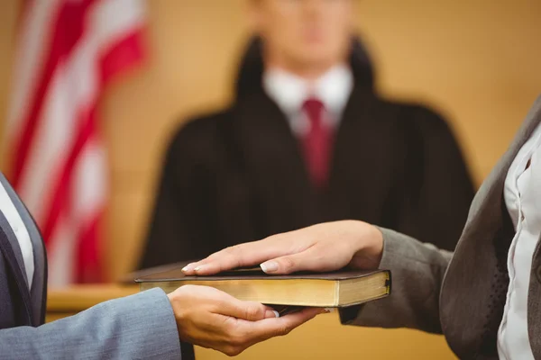 Testigo jurando sobre la Biblia diciendo la verdad — Foto de Stock