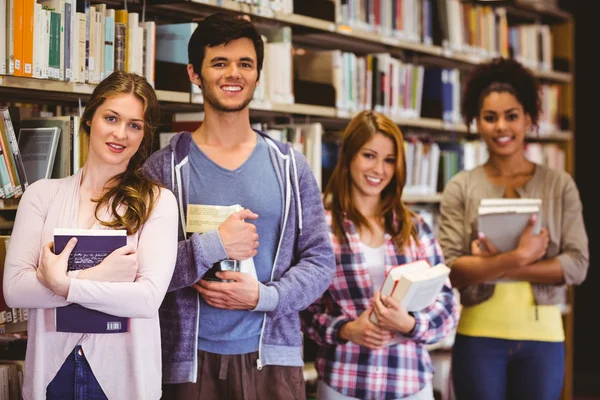 Heureux étudiants tenant des livres en rangée — Photo